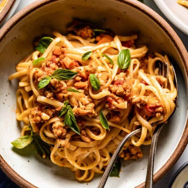 Chicken Bolognese in a bowl with a fork from the top view.